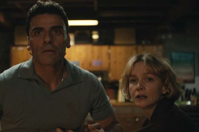 Oscar Isaac and Carey Mulligan star in Beef season 2; they are stood in their garage, looking alarmed and staring out at something in the distance