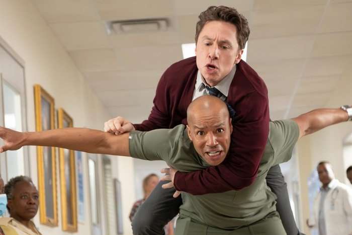 Turk attempts to carry JD in his back, but the two are visibly struggling in this scene from Scrubs season 10