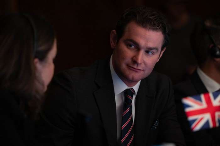 Mark Stanley as Ryan in Secret Service, wearing a suit and looking to Rochenda Sandall as Melissa.