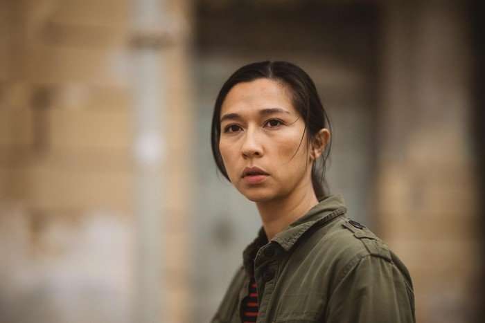 Aoife Hinds as Julie in Secret Service, wearing a green jacket and stood outside.