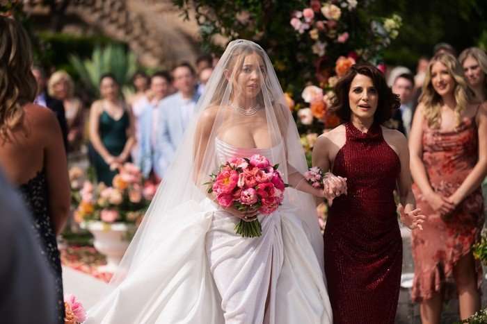 Sydney Sweeney as bride Cassie Howard (left) is walked down the aisle by Alanna Ubach as Suze Howard in Euphoria season 3.
