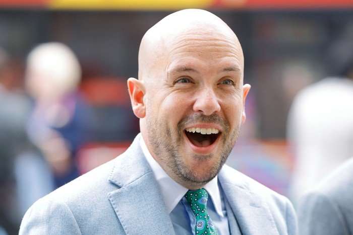 Tom Allen walking into a chapel, wearing a light blue blazer.