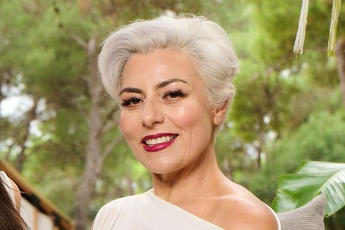 A close up of Dr Danielle Harel smiling ahead. She has white hair styled in a short updo.