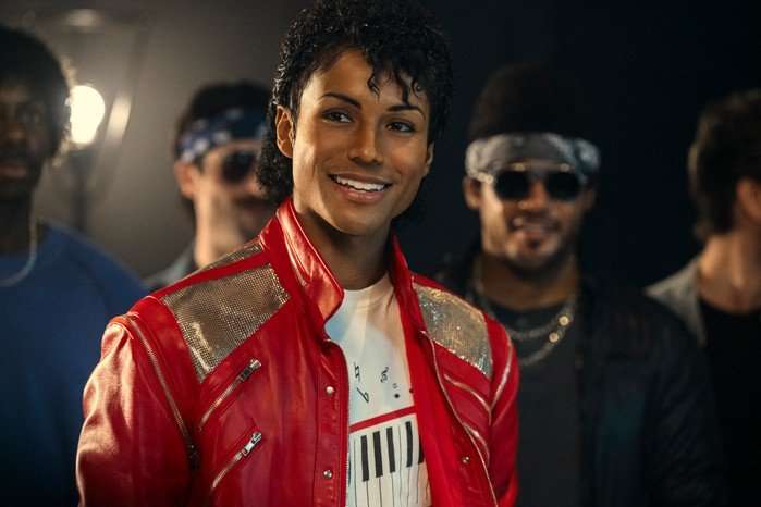 Jaafar Jackson as Michael Jackson in Michael Jaafar Jackson as Michael Jackson in Michael. He smiles just away from the camera wearing the singer's iconic red and gold jacket.