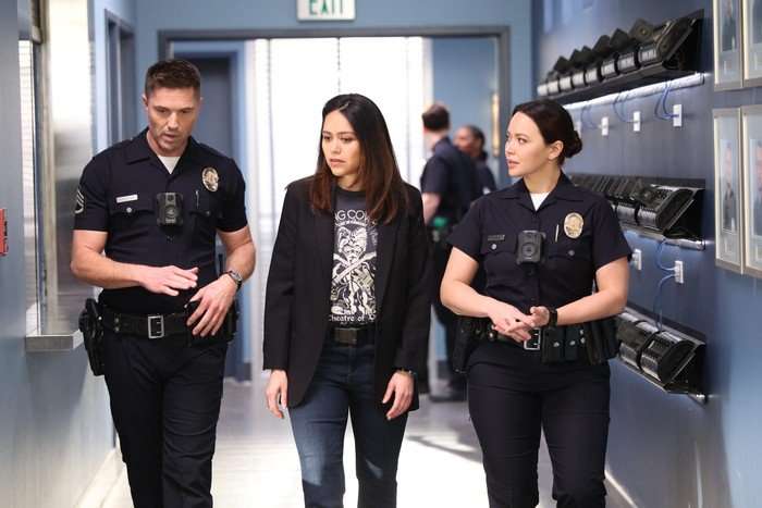 Eric Winter as Tim Bradford, Alyssa Diaz as Angela Lopez and Melissa O'Neil as Lucy Chen, walking down a corridor together in The Rookie