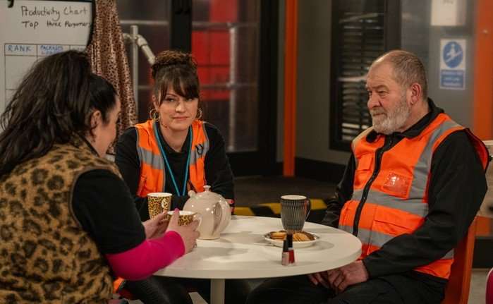 Bear, Mandy and Kerry sit in fluorescent orange vests in the depot in a scene from Emmerdale
