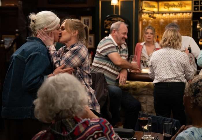 Dr Todd kisses Vanessa as Charity watches on in a scene from Emmerdale