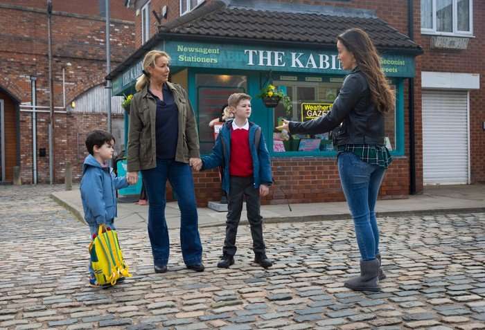 Jodie chats to Cassie, who is holding Dorin and Bertie's hands in Coronation Street