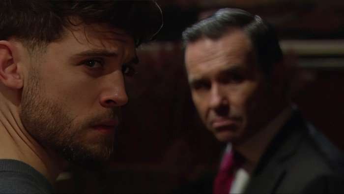 Joe and Graham look sideways in a scene from Emmerdale