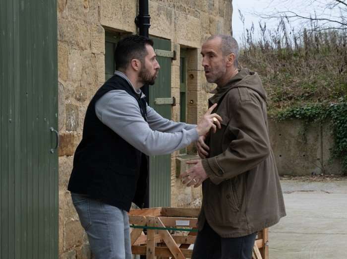 Ross pushes Sam away from a barn in Emmerdale