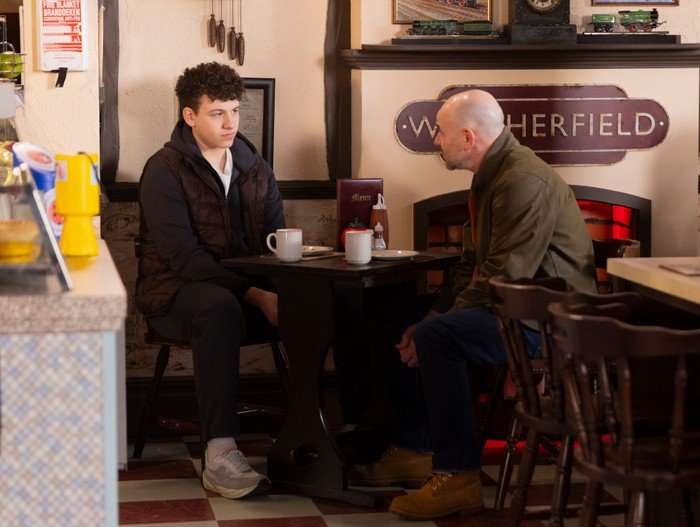 21_05_coro_will_tim Will and Tim sit in the caff in Coronation Street