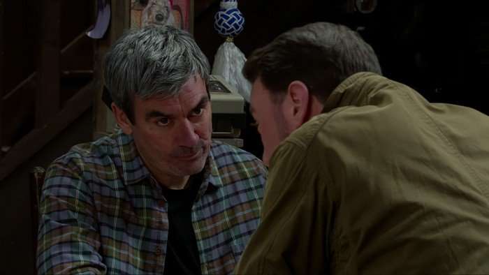 Liam talks to Cain in Wishing Well Cottage in a scene from Emmerdale