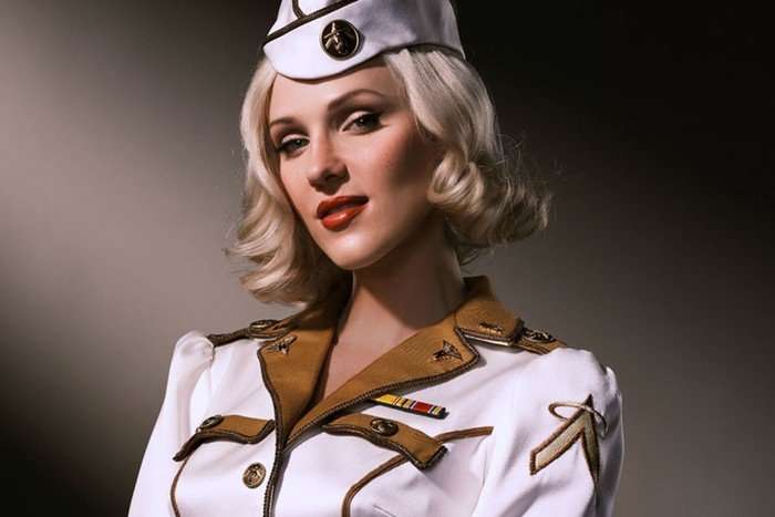A blonde woman in a white and gold uniform and hat poses for the camera