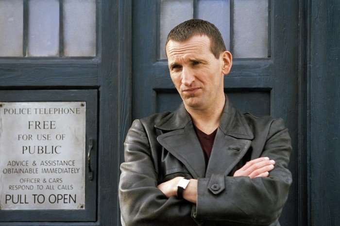 Christopher Eccleston as the Ninth Doctor in Doctor Who stood by the TARDIS