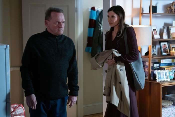 Bea stands sheepishly beside Billy in a scene from EastEnders