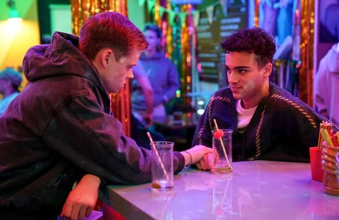 Oscar holds Josh's hand in The Albert in EastEnders