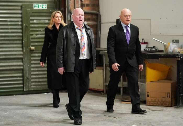 Sam, Phil and Mark charge into a warehouse in EastEnders