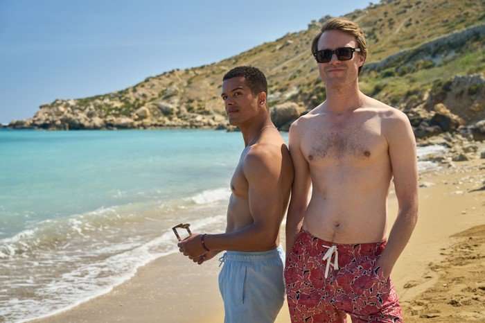 561624,TITLE:Two Weeks In August Dylan Brady as Will and Hugh Skinner as Jacob in Two Weeks in August. They are both topless and wearing swimshorts, and stood on a beach.