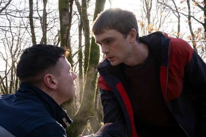 Mitchell Robertson as Young Niall and Stuart Campbell as Young Ruben in Half Man. There are trees behind them, and Niall is looming over Ruben.