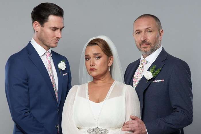 563006,TITLE:Eastenders Vicki, in a wedding dress, stood between Zack and Ross in key art for EastEnders