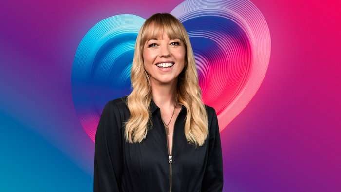 Sara Cox stood smiling ahead wearing an all black outfit.