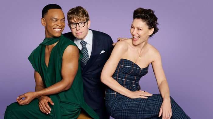 566903,TITLE:Strictly Come Dancing 2026 Johannes Radebe, Josh Widdicombe, and Emma Willis pose in front of a purple background.