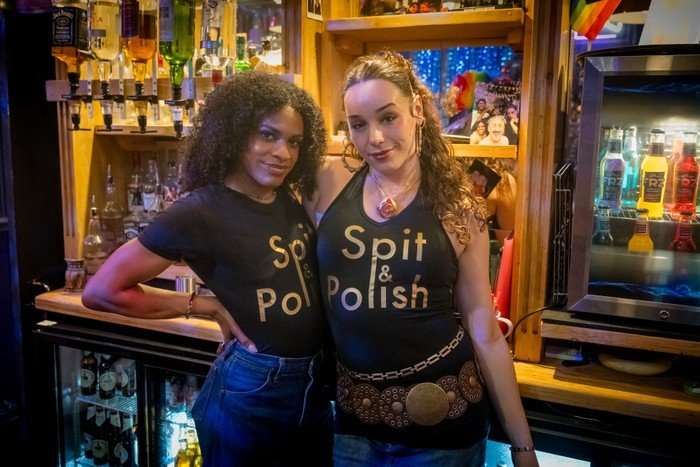 Shakeel Kimotho and Iz Hesketh stand in a gay bar, wearing t-shirts with 'Spit & Polish' written on them &ndash; the name of the fictional venue from Tip Toe