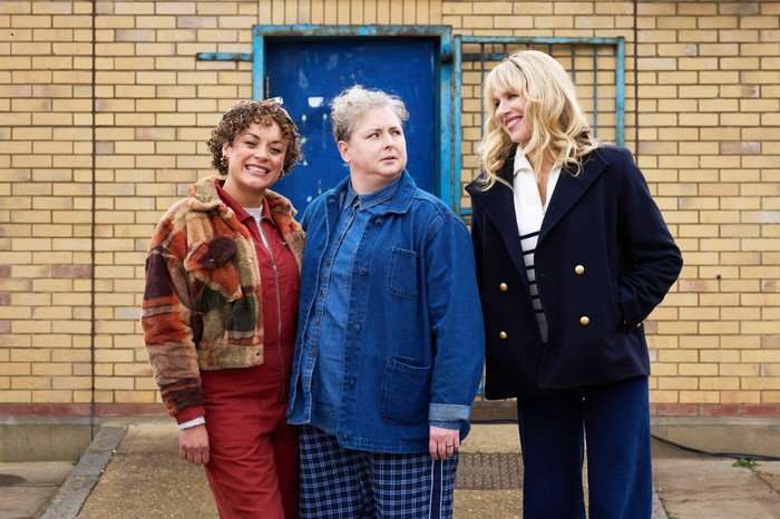 Rochenda Sandall as Fi and Siobhan McSweeney as Della, stansing next to Amanda, who's looking at them with a possessed grin on her face