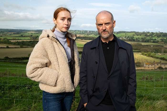 Chloe Harris 'Jessie Elland' and dad Harry/Damon Harris 'Robert Beck' standing together in front of fields, looking into camera