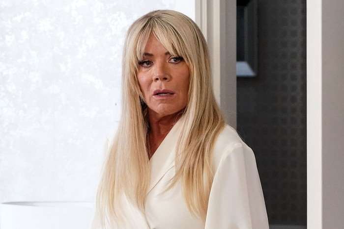 EastEnders Sharon Watts 2025 Letitia Dean as Sharon Watts in a white blouse looking shocked in EastEnders.