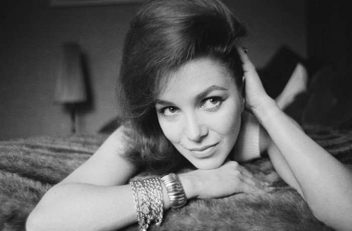 A black and white image of Jill Curzon, lying down with her face close to the camera and her hand on her head