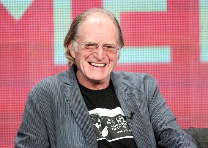 David Bradley David Bradley wearing a grey jacket and black T-shirt, smiling.