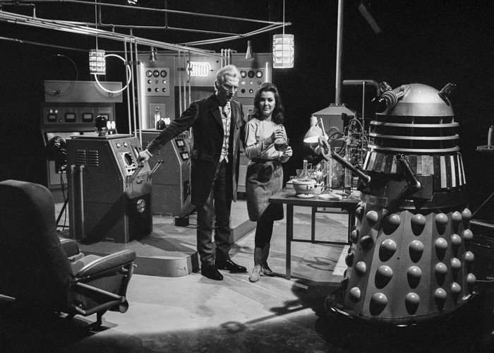 A black and white photo of Peter Cushing and Jill Curzon filming Dalek Invasion 2150 AD