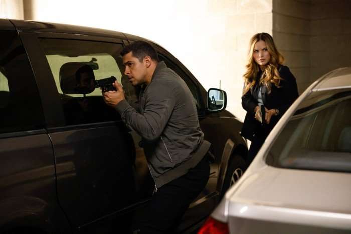 Wilmer Valderrama as Special Agent Nicholas "Nick" Torres and Katrina Law as Special Agent Jessica Knight in NCIS. They are stood by a car and holding guns