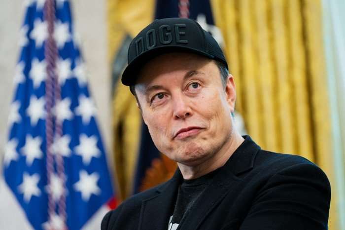 Elon Musk Elon Musk, wearing a black cap with DOGE written on it, stood in the Oval Office with the US flag behind him