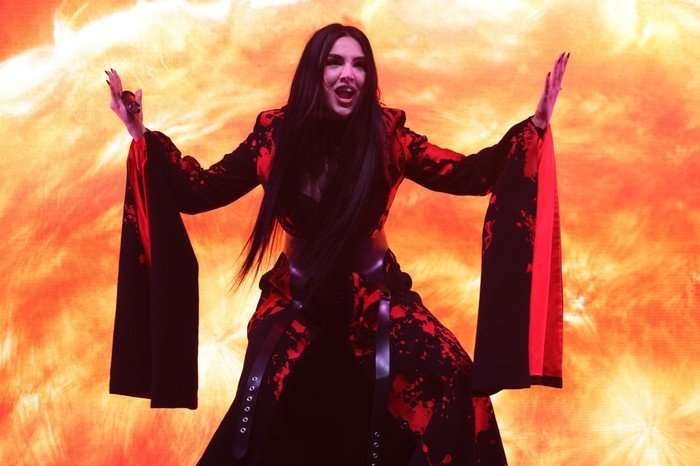 Tamara Živković, who will represent Montenegro at the Eurovision Song Contest stood on stage wearing a black and red gown with her arms stretched out.