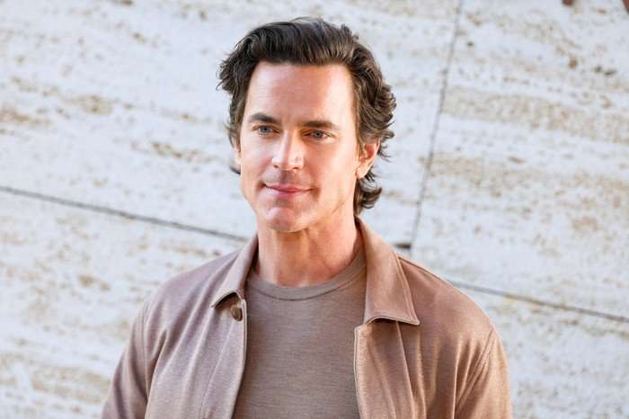 Falconeri Dinner Celebrating the Ultrafine Cashmere Collection Matt Bomer photographed at a Falconeri event in April 2026. He is wearing a tan brown jacket and matching t-shirt, smiling and looking straight ahead