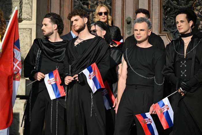 AUSTRIA-ENTERTAINMENT-MUSIC-TELEVISION-ESC Serbian singers Luka Arandelovic, Pavle Arandelovic, Andrija Cvetanovic, Pavle Samardzic, Nikola Petrovic and Bojan Ilic of metal band Lavina dressed in all black and holding Serbian flags, looking ahead of them.