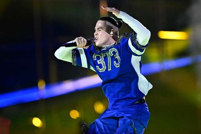 Moldovan singer Vlad Sabajuc, aka Satoshi pictured mid jump as he sings into a microphone.