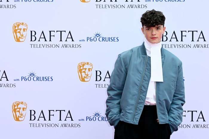 Owen Cooper poses on the red carpet of the BAFTA Television Awards 2026 in a blue jacket and white shirt.