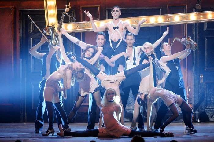 2014 Tony Awards - Show A group of perfomers on stage in a performance of Cabaret, with Alan Cumming in the middle held up by his castmates.