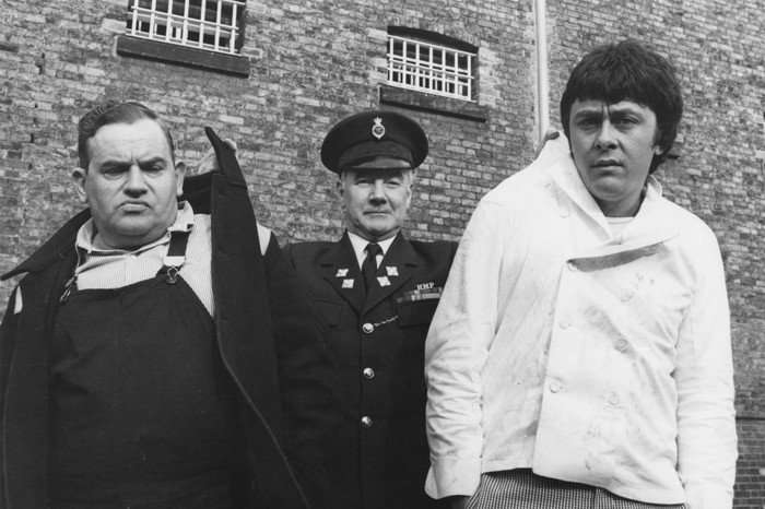 Porridge Ronnie Barker (as Fletcher), Fulton MacKay (as Officer Mackay) and Richard Beckinsale (as Godber). They are being held by the collars of their shirts by Fulton.