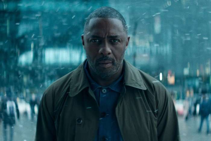 Hijack_Photo_020109-edit Idris Elba standing in the street while snow falls around him in Hijack season 2.