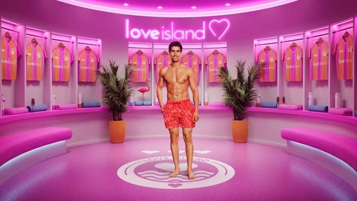 ©ITV Samraj stood smiling wearing orange swim shorts.