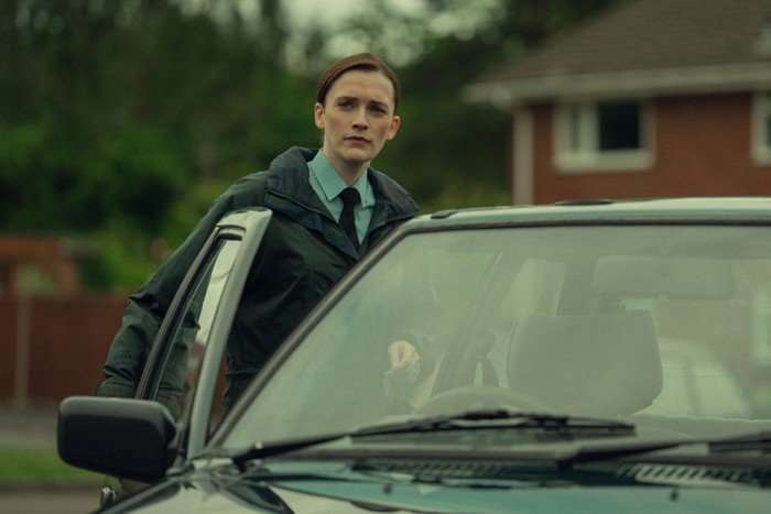 Charlotte Ritchie as Sophie in Legends, opening a car door and wearing a blue uniform.
