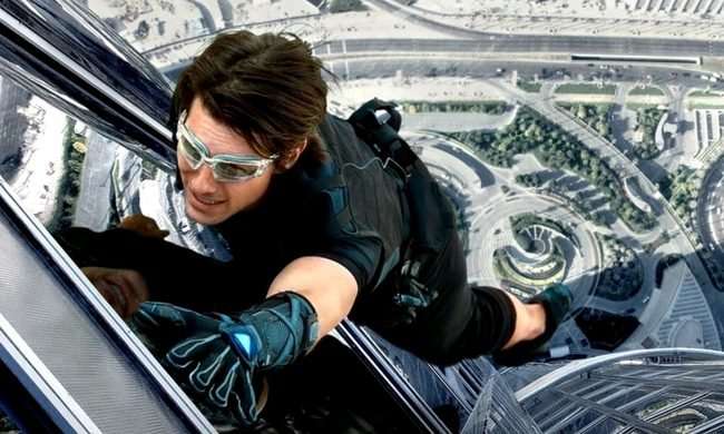 Tom Cruise as Ethan Hunt climbing the side of a building in Mission: Impossible - Ghost Protocol.