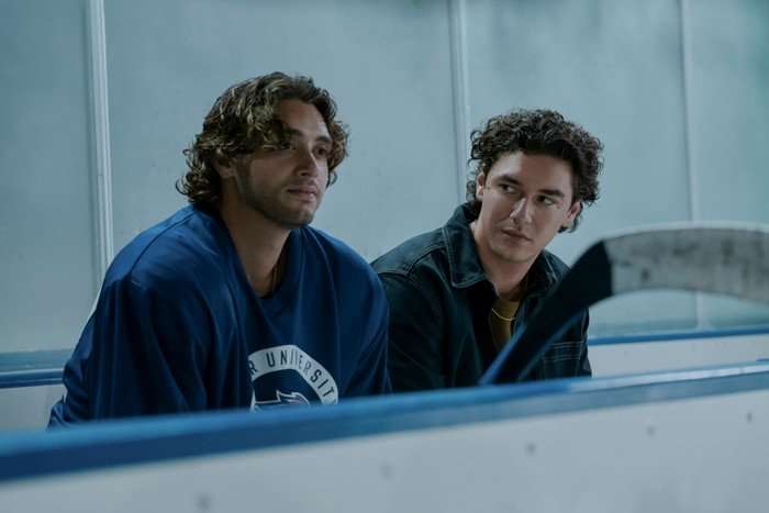Off Campus John and Garrett sit on the bench just off an ice hockey rink, looking serious as they share a private conversation