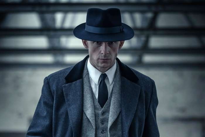 Jamie Bell as Duke Shelby in Peaky Blinders sequel series. Duke Shelby wearing a hat and suit.