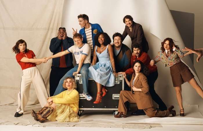 Celeste Dring, Hammed Animashaun, Larry Dean, George Fouracres, Jack Shep, Ayoade Bamgboye, Al Nash, Paddy Young, Ania Magliano, Annabel Marlow and Emma Sidi posing for a picture in a variety of poses, all laughing and smiling.