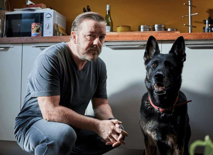 Ricky Gervais, After Life (Netflix) Ricky Gervais sitting with a German shepherd dog on a sofa looking to the camera